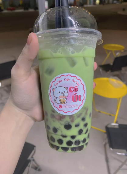 Ly đồ uống màu xanh có tem tròn màu hồng